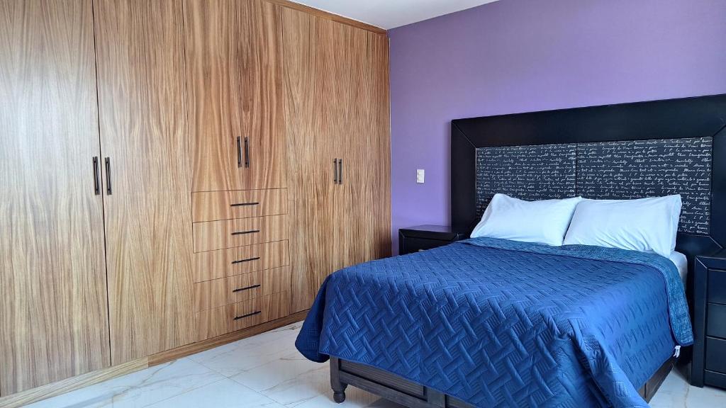 a bedroom with a bed and wooden cabinets at Depas Ocampo in Morelia