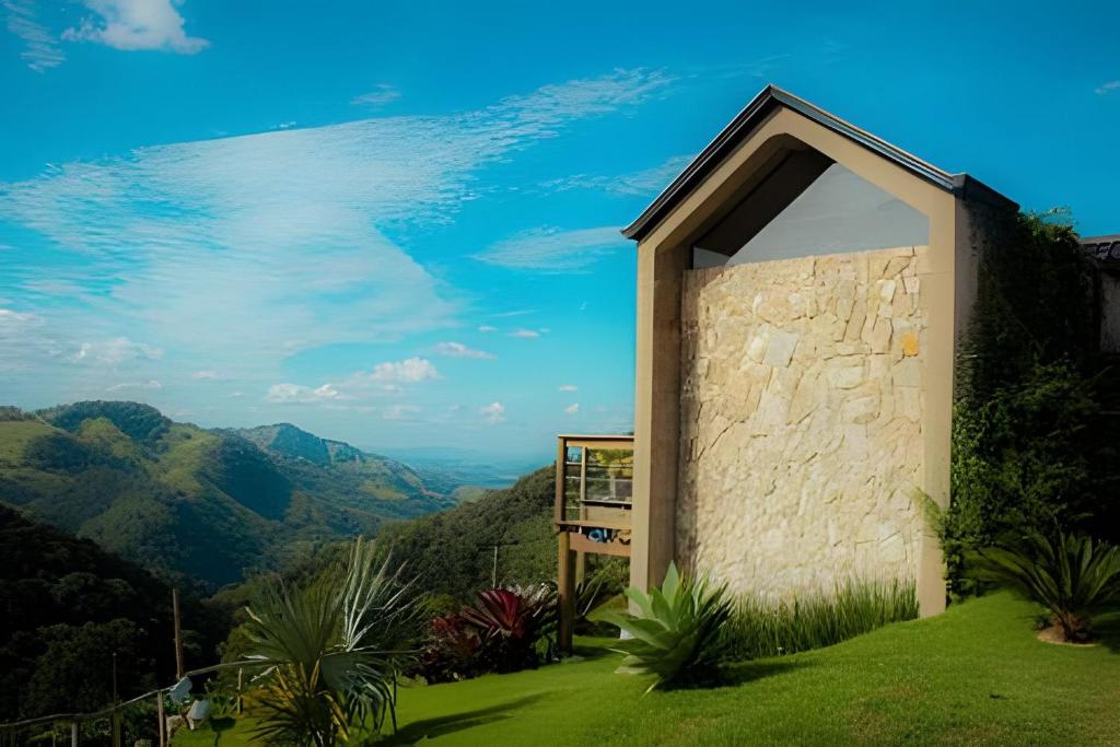 a building with a window on the side of a mountain at Cabana do Café - Olivais Santa Clara in Cambuí