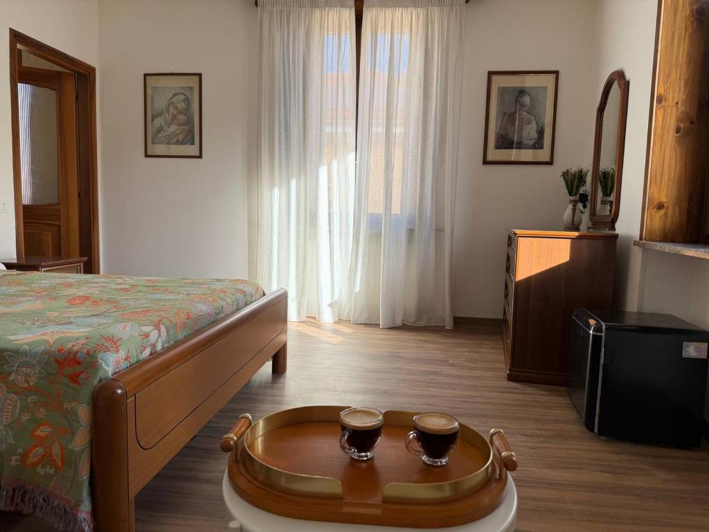 a bedroom with a bed and a table with two cups on it at "The Moment"- rooms Bergamo center, self check-in, late Arrivals in Bergamo