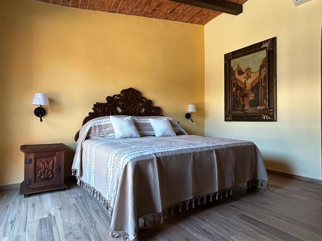 a bedroom with a bed and a painting on the wall at Hacienda Casa Grande, suite esmeralda in Guadalajara