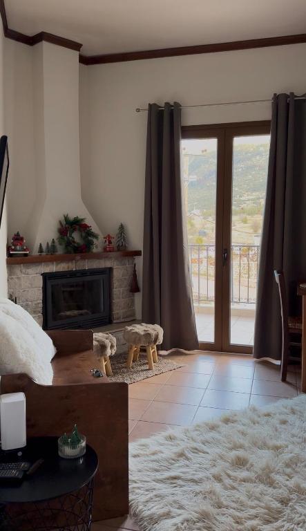 a living room with a fireplace and a sliding glass door at Valley Parnass in Arachova
