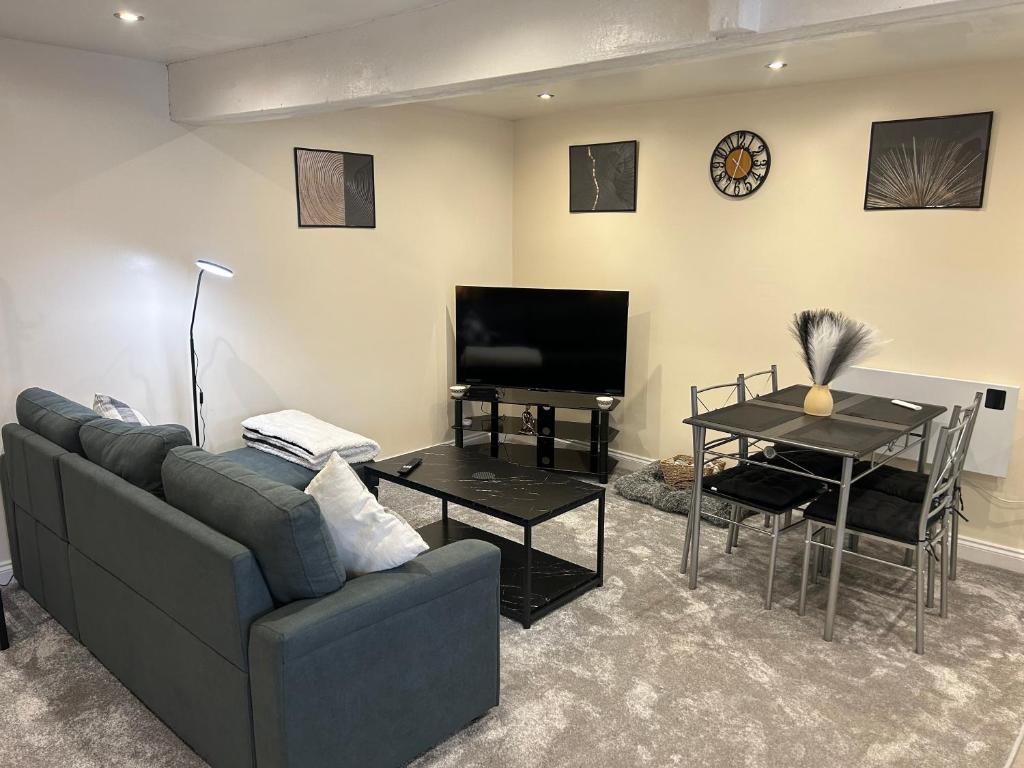 a living room with a couch and a tv and a table at Studio 1 in Howden