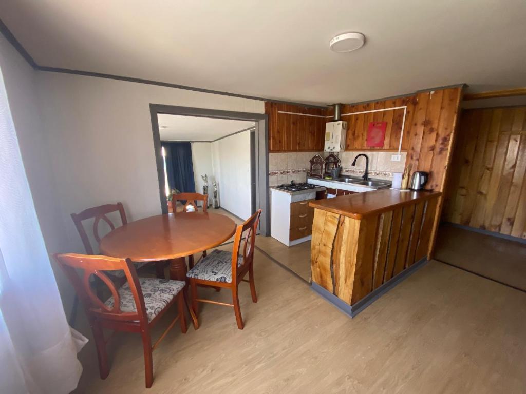 a kitchen with a wooden table and a table and chairs at San Joaquin in Curacautín