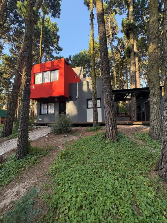 a house with a red roof in the woods at BOSQUE LIBERTAD Casa Planta Baja in Mar Azul