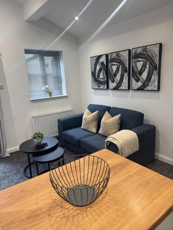 a living room with a blue couch and a table at Cozy bungalow in Standish