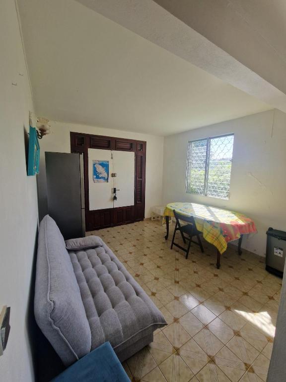 a living room with a couch and a table at Holiday rental House in Schœlcher
