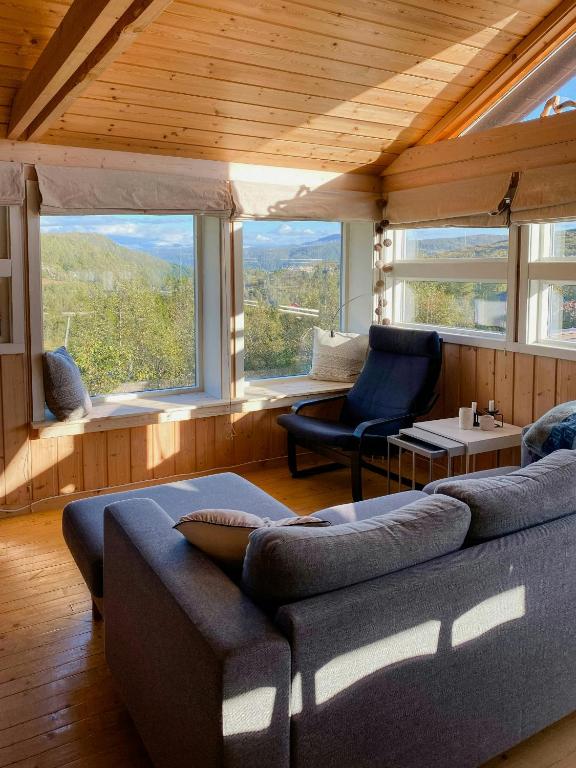 a living room with a couch and a large window at Mountain Cabin With Glacier Views in Norheimsund