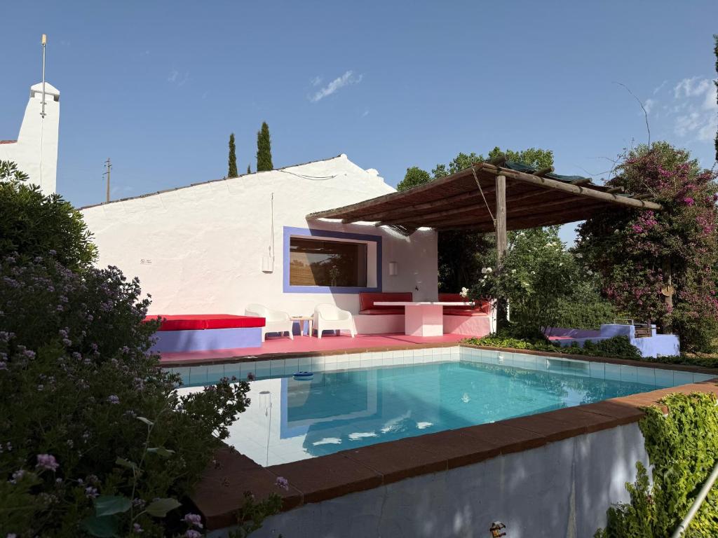 a swimming pool in a backyard with a house at Courela do Monte Novo in Monte de Jangeis de Cima