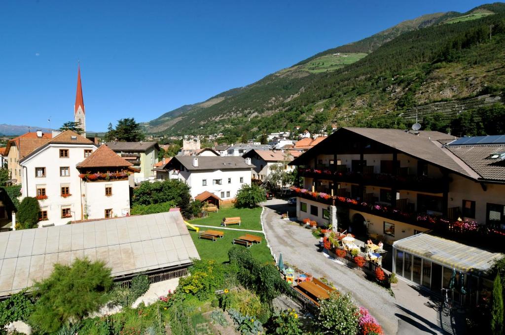 Une petite ville avec des bâtiments et une montagne dans l'établissement Landhotel Anna, à Silandro