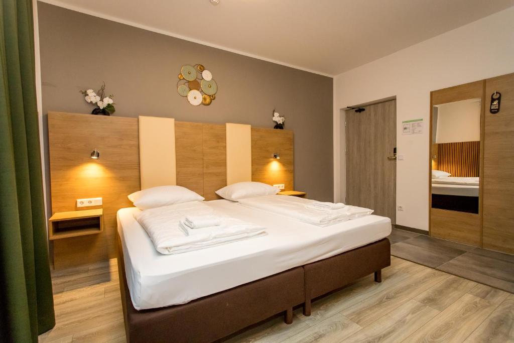 a bedroom with a large bed with white sheets at Conco Leipzig in Leipzig
