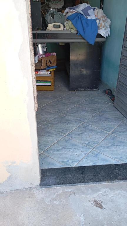 a room with a table and a tiled floor at Kitnet Ateneu in Vila Velha