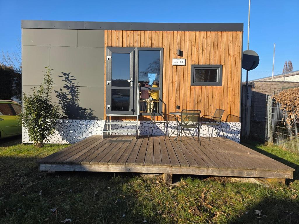 a tiny house with a deck with a dog in it at Tiny House Beilngries in Beilngries