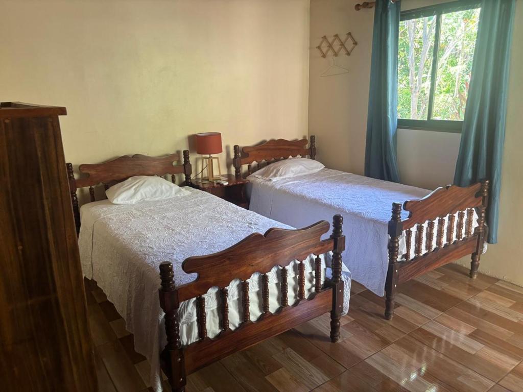 a bedroom with two beds and a window at Jardines del Golfo in Lepanto