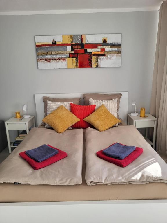 a bed with red and blue pillows on it at Bergzauber Bayerwald - voll ausgestattetes Familienapartment mit Pool in Sankt Englmar