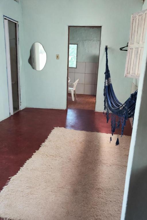 a living room with a hammock in the middle of the room at Chalé Rústico Cumuruxatiba in Cumuruxatiba