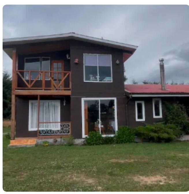 a brown house with a porch and a balcony at Casa Arrayán con vista al volcan in Frutillar