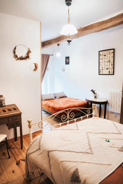a bedroom with a bed and a mirror at Chambre d'hôtes La clef des Champs - LA SOURCE DE NOS RACINES - CORPS DE FERME AU COEUR DU PARC NATUREL DE L'AVESNOIS in Beaufort