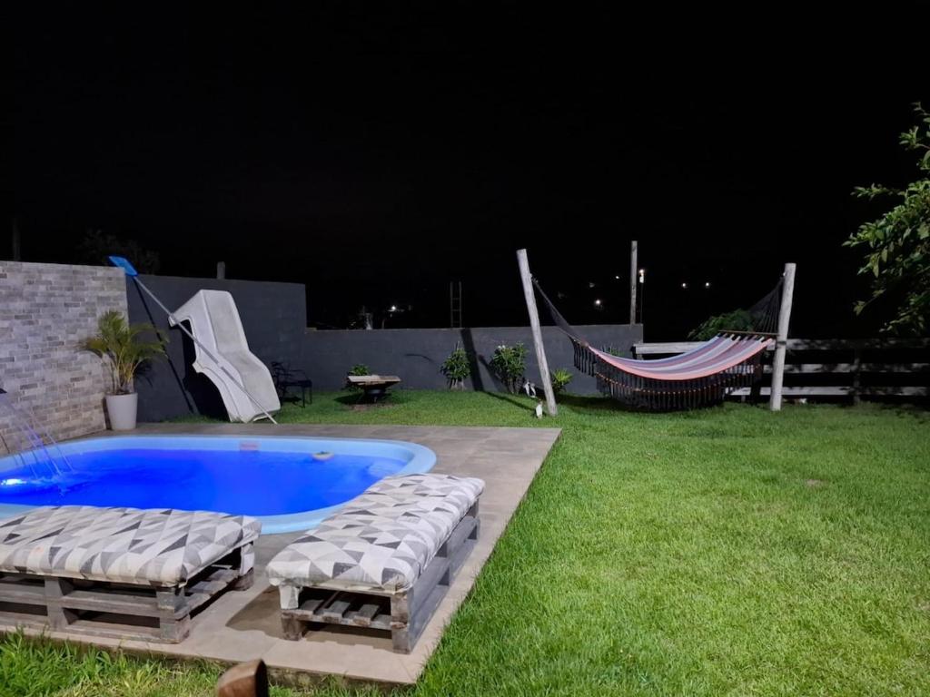 a backyard with a swimming pool and a hammock at Loft das Maritacas - Conservatória in Valença