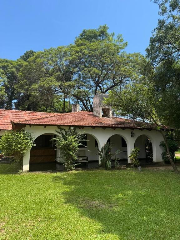 an old house with a red roof and a yard at Casa ByJ en El Paso in Paso de la Patria