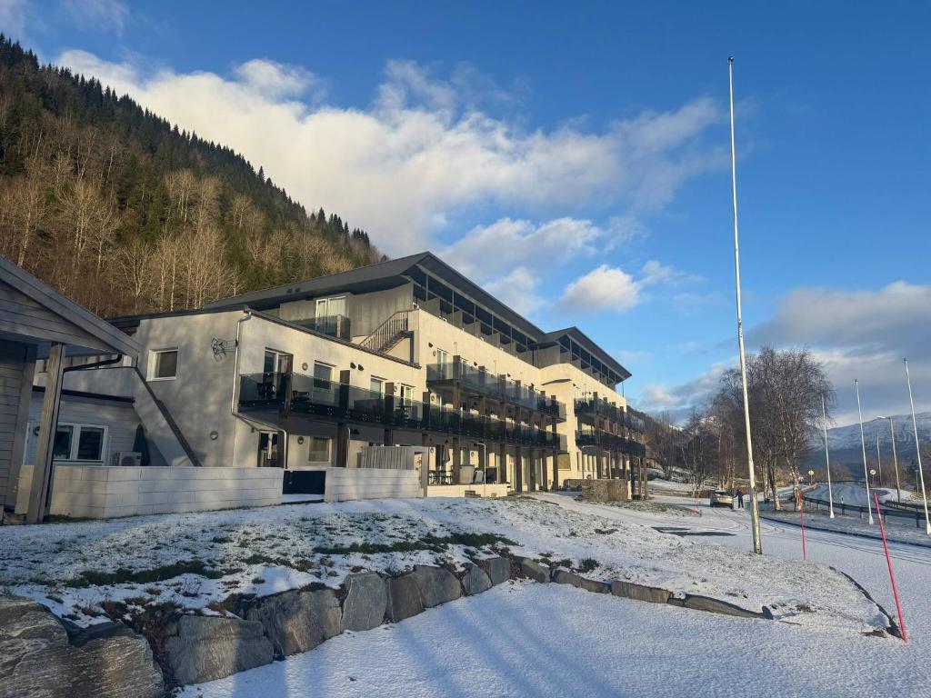a large building with snow on the ground at Oppheim Resort - Pool, Sauna & Lake! in Vossevangen