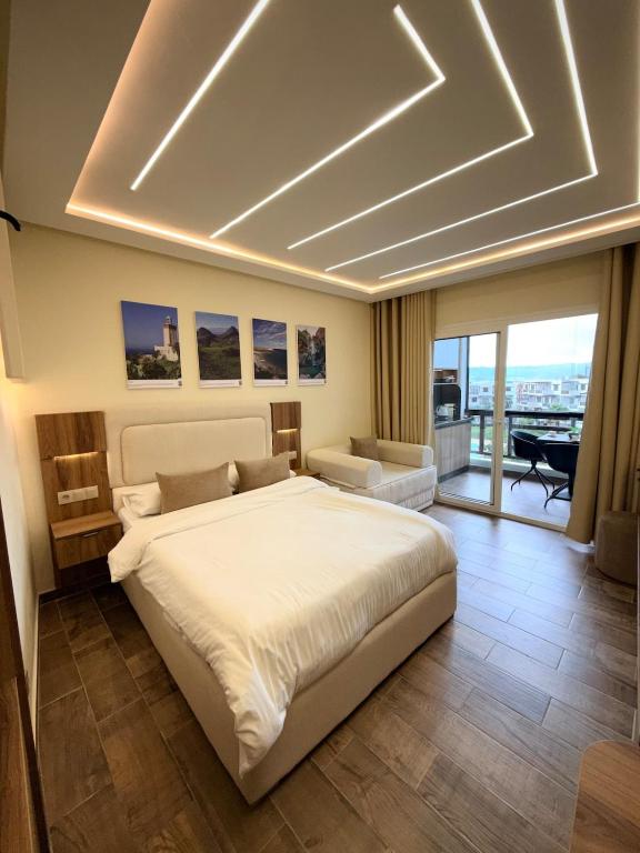 a bedroom with a large bed and a living room at Chic studio with balcony, quiet & bright in Tétouan