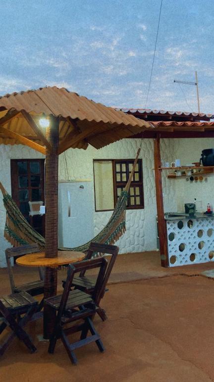 a patio with a table and two chairs and a hammock at BELL MAR CHALÉs 03 in Luis Correia