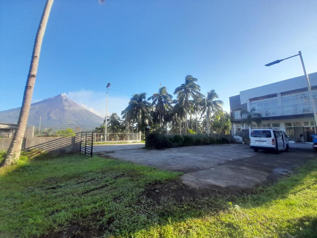 a white van parked in a parking lot in front of a building at Maison De Gloria in Locsin
