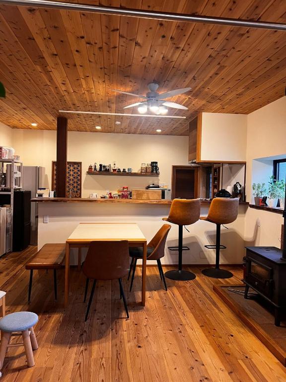 a kitchen with a wooden ceiling and a table and chairs at HAPPY MAGIC guesthouse in Tateyama