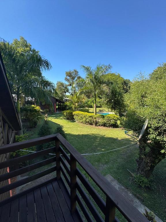 a wooden deck with a view of a yard at Cabaña DOS Refugio in Paso de la Patria