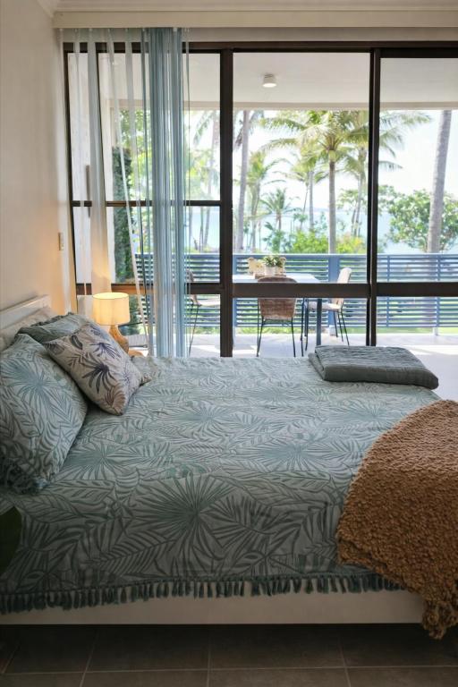 a bedroom with a bed with a view of a patio at La Plage Cabane in Eimeo