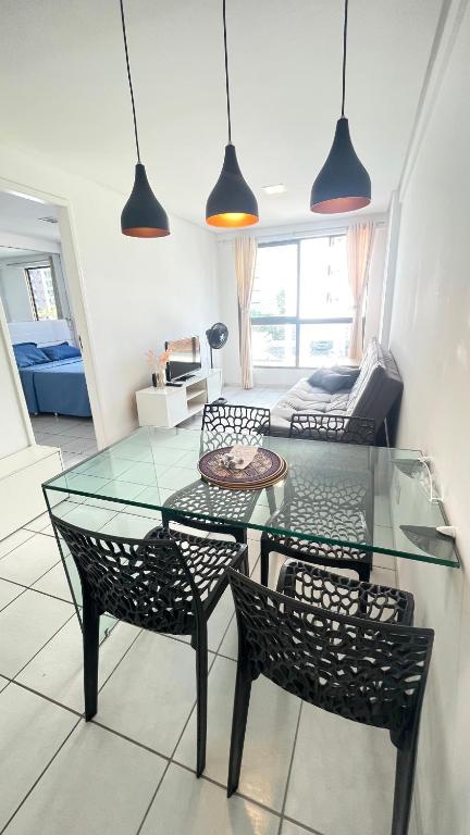 a glass table and chairs in a living room at Flat Jardins Madalena in Recife