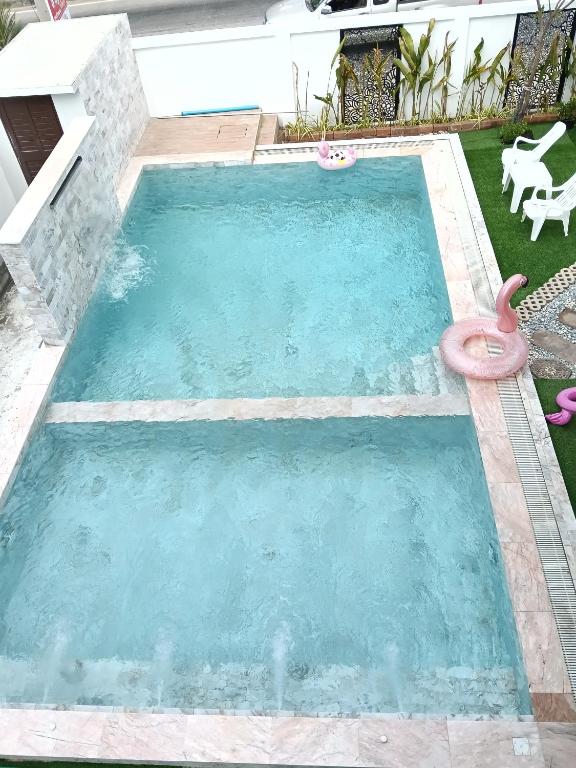 a swimming pool with a pink flamingo in a yard at Loft Life Pool villa in Ban Huai Yai