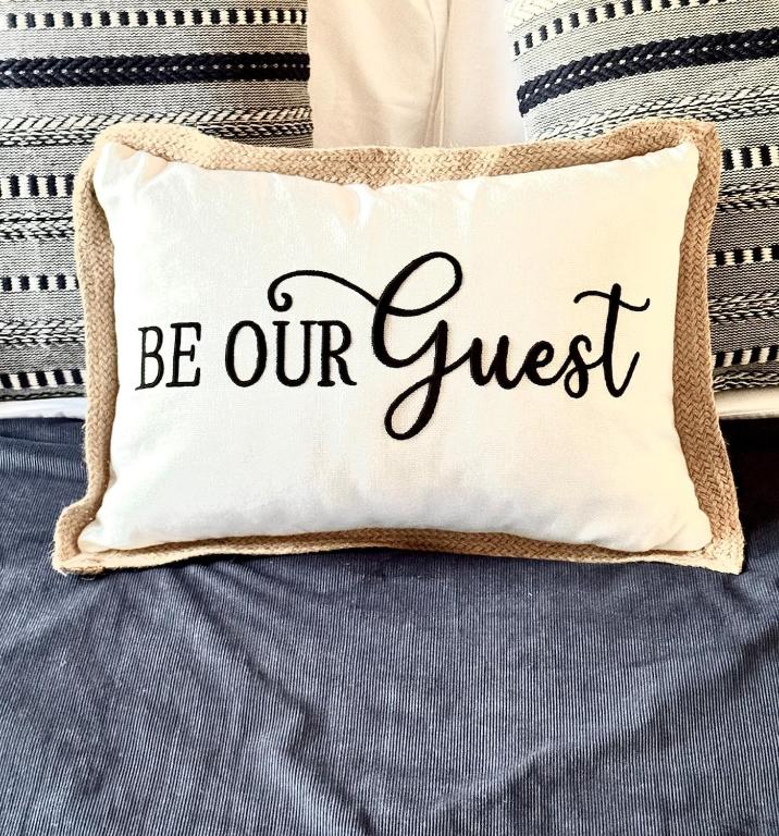a pillow with the words be our guest at Lakefront Condo Private Deck 3 Pools in Osage Beach