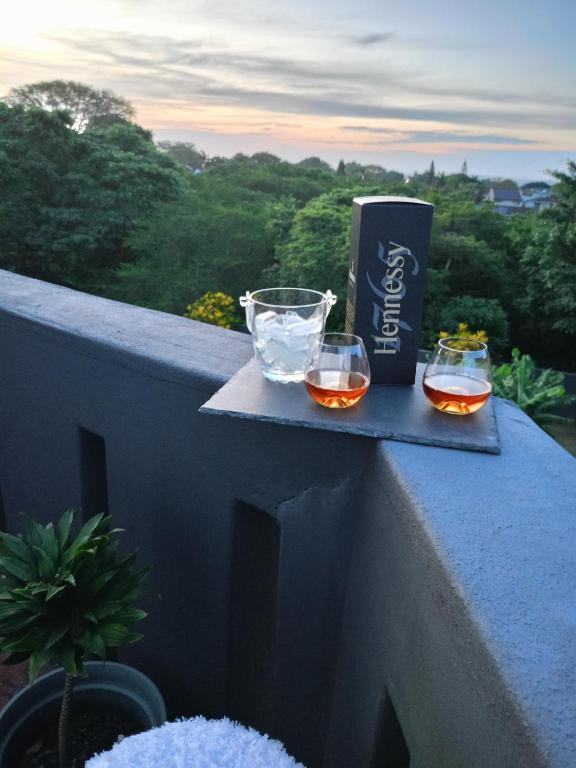 two glasses of wine and a can on a ledge at Vanilla Lee Guest House in Richards Bay