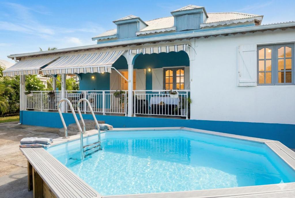 a swimming pool in front of a house at Ameli'ber in Sainte-Rose