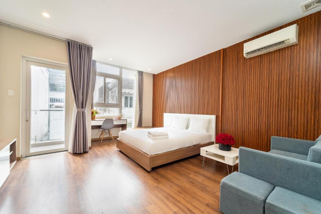 a bedroom with a bed and a blue couch at Jade House Tran Cao Van in Ho Chi Minh City