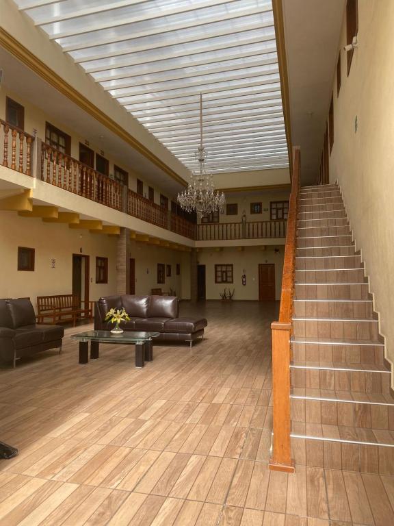 a large living room with couches and a staircase at Hotel Jocari in Cholula