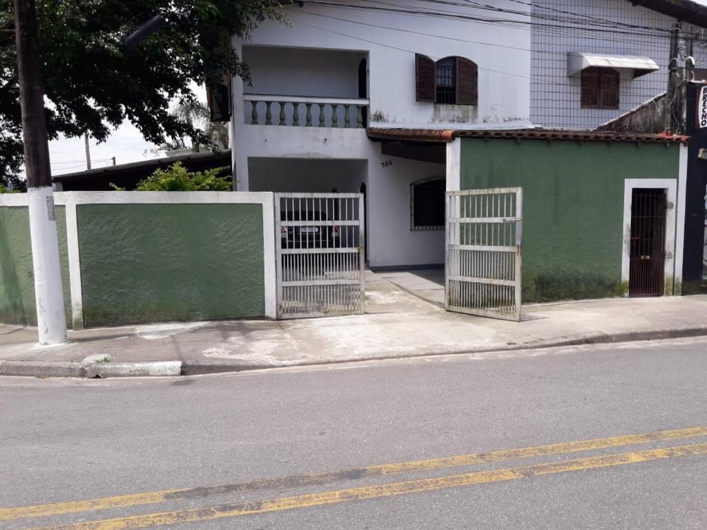 a building with a fence on the side of a street at casa de praia grande e espaçosa in Bertioga