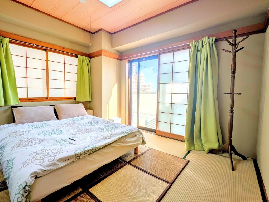 a bedroom with a bed and a large window at Apt熱海 in Atami