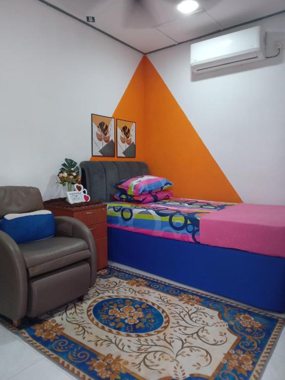 a bedroom with a bed and a chair and a rug at KAMI roomstay 2 in Kampong Banggol Lalang