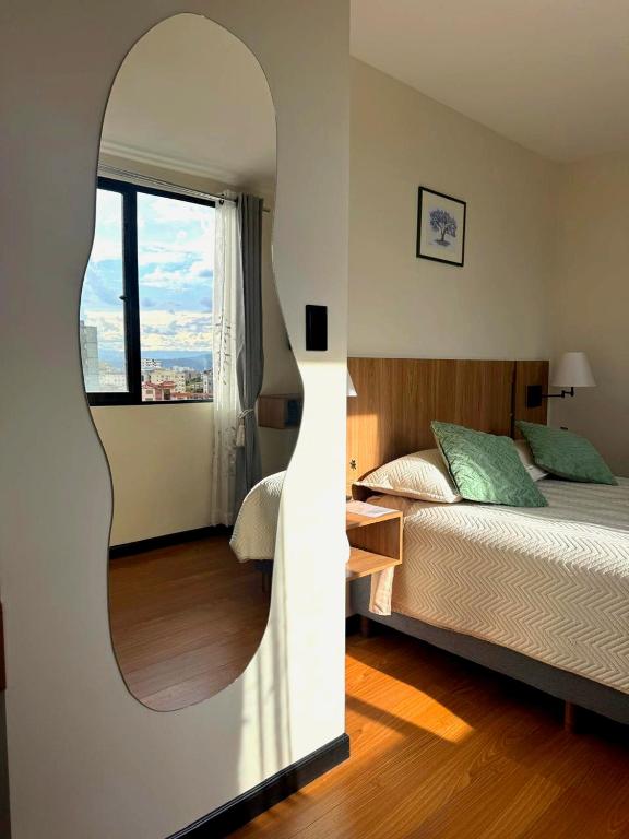a bedroom with a bed and a large mirror at Urban Escape Sky View in Cochabamba