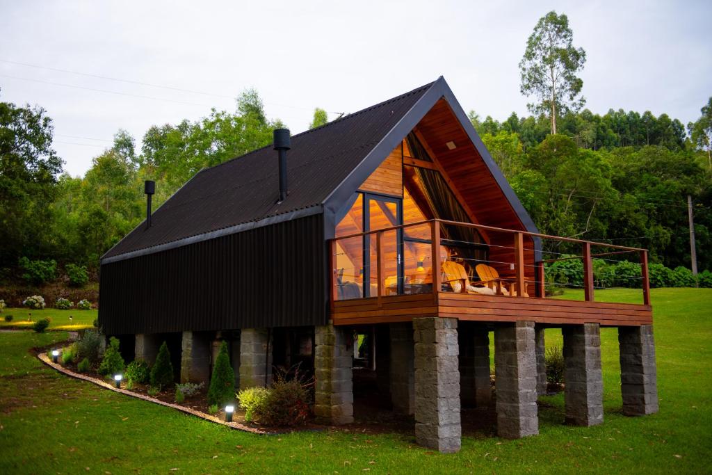 a house with a wrap around porch with a deck at Cabana Terra - Hidro com vista, Lareira e Café da manhã in Nova Petrópolis