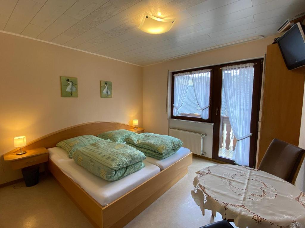 a bedroom with a bed and a table in it at Gästehaus im Oberdorf in Erden