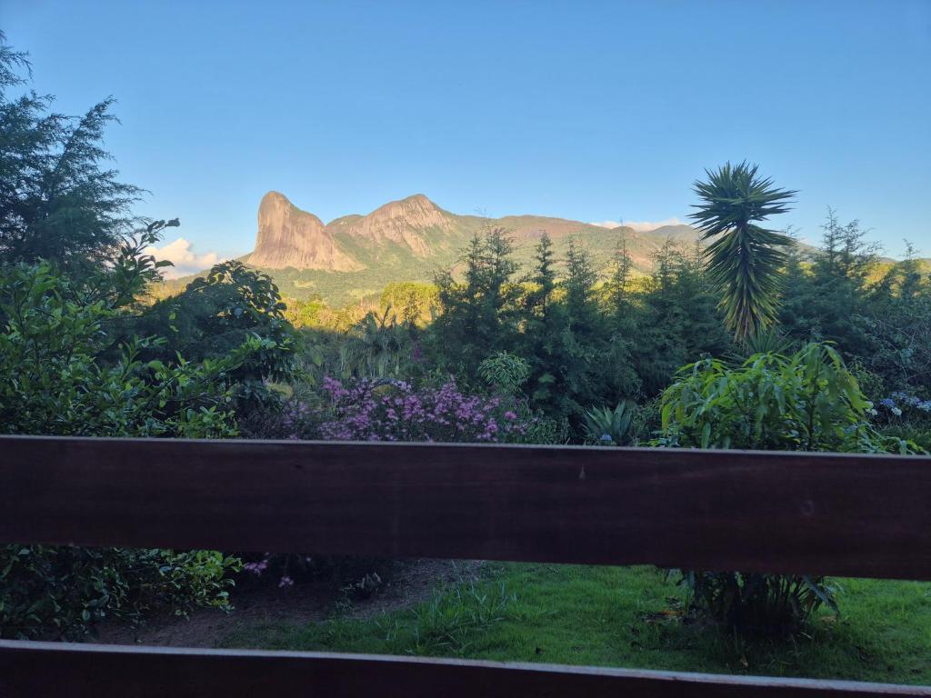 a view of a garden with mountains in the background at Pedra Azul Chalé Clássico in Domingos Martins