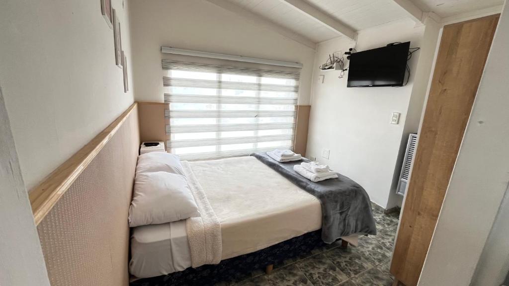 a small bedroom with a bed and a television at Estrellas del Sur in Río Gallegos