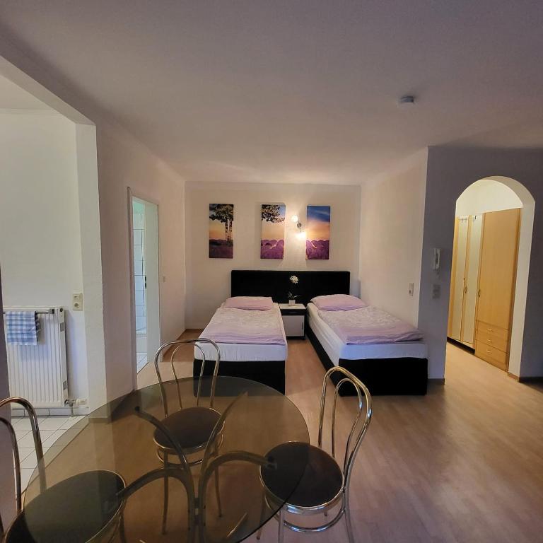 a room with two beds and a table and chairs at Apartment Weimar II in Ulla