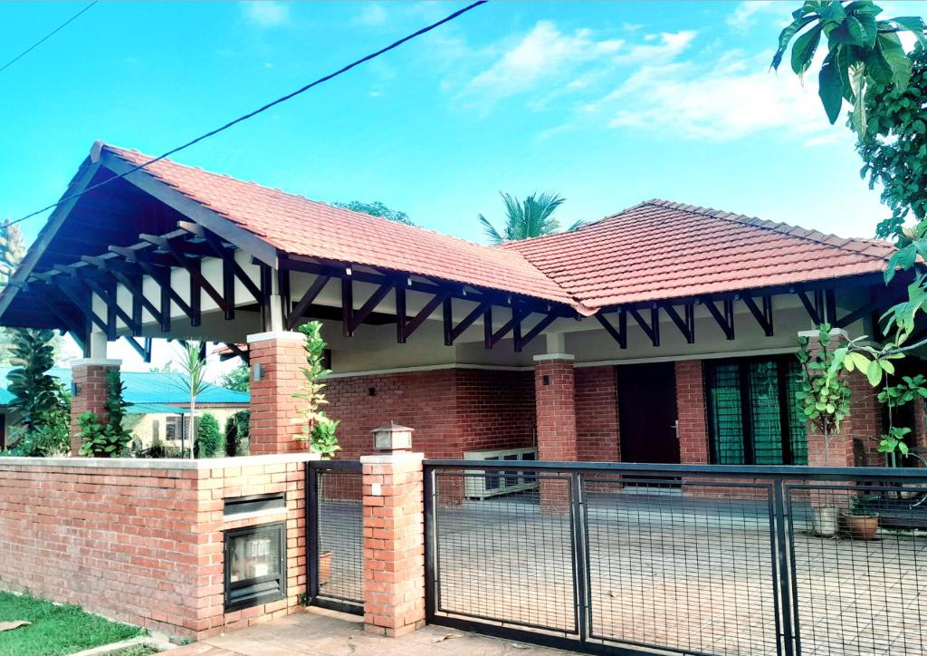 a brick house with a blue an awning at Teratak Assofiyya 4 Bilik in Sungai Petani