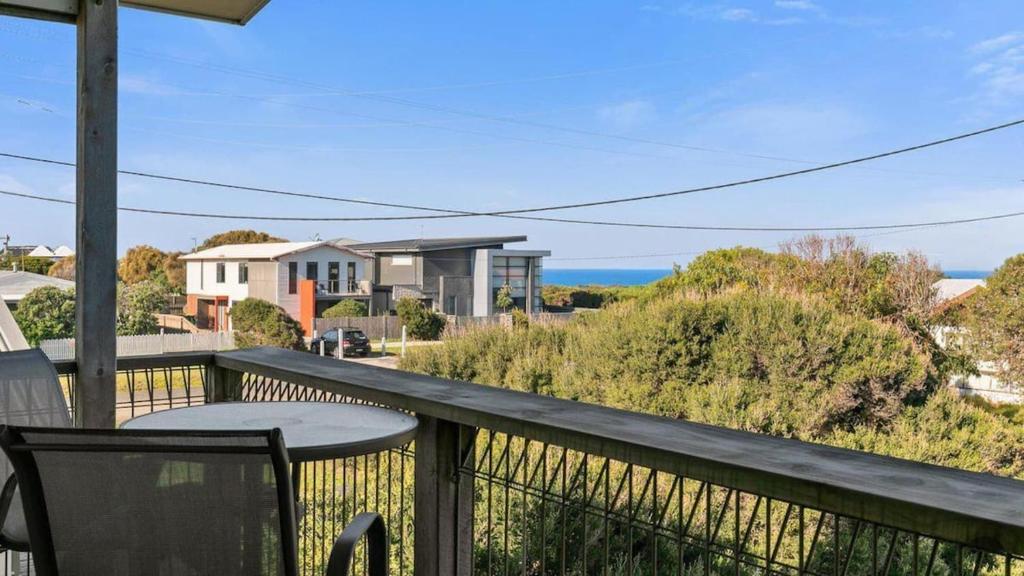 a balcony with a table and a view of the ocean at Beach Serenity in Sunderland Bay