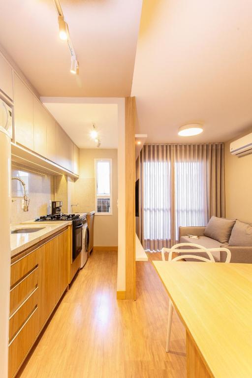 a kitchen and living room with a couch and a table at Apt 1012 Conforto aconchego e vibe acolhedora in Santa Maria