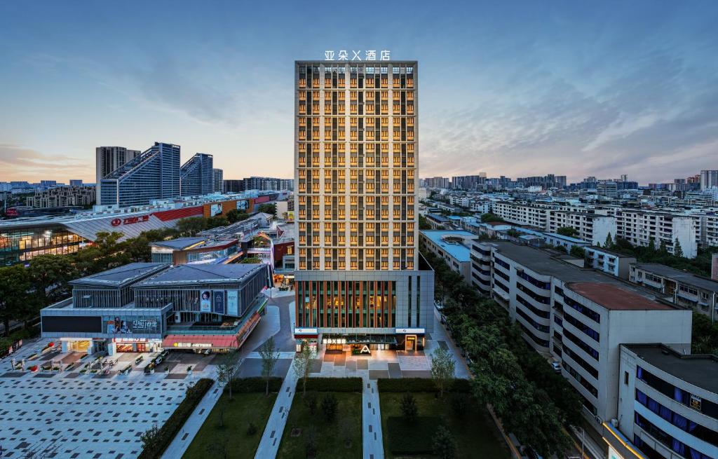 a tall yellow building in the middle of a city at Atour X Hotel Chengdu Qingbaijiang Wanda in Chengdu